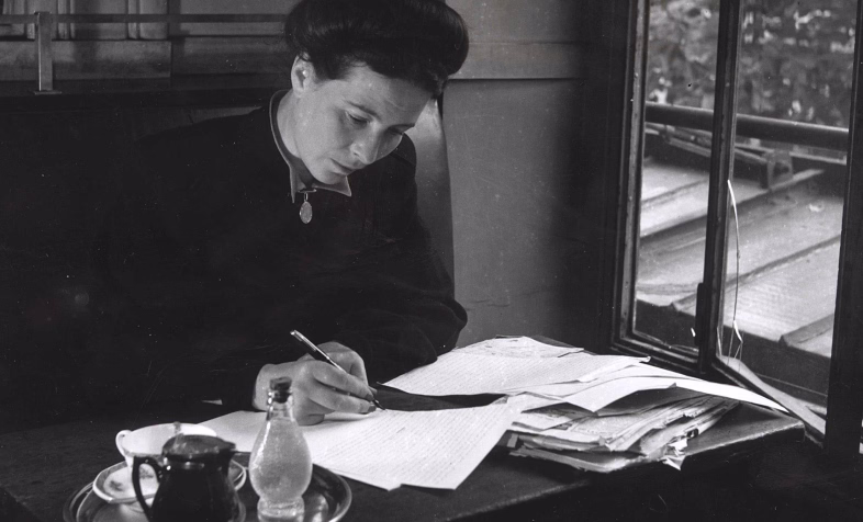 Photo d'une femme en train d'écrire dans un carnet